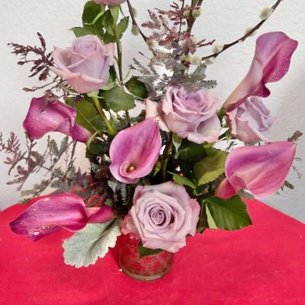 Lavender roses and pink calla lilies in a glass vase