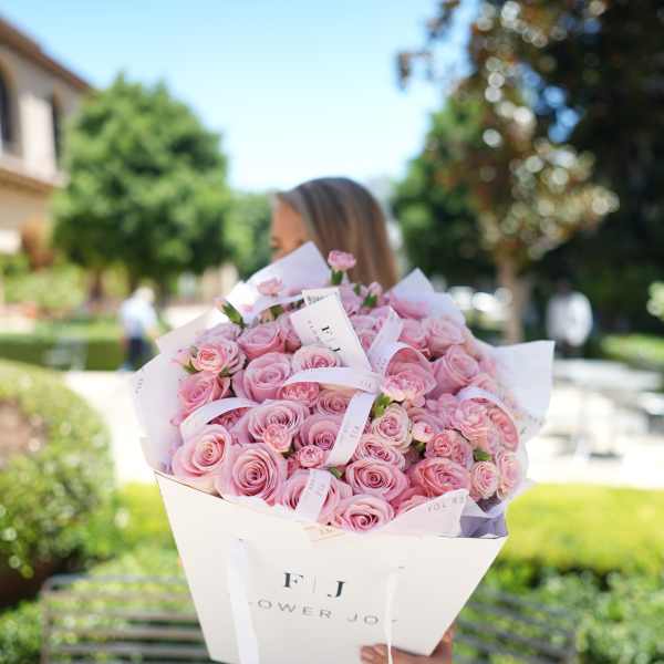 Large bouquet of pink roses wrapped in white paper