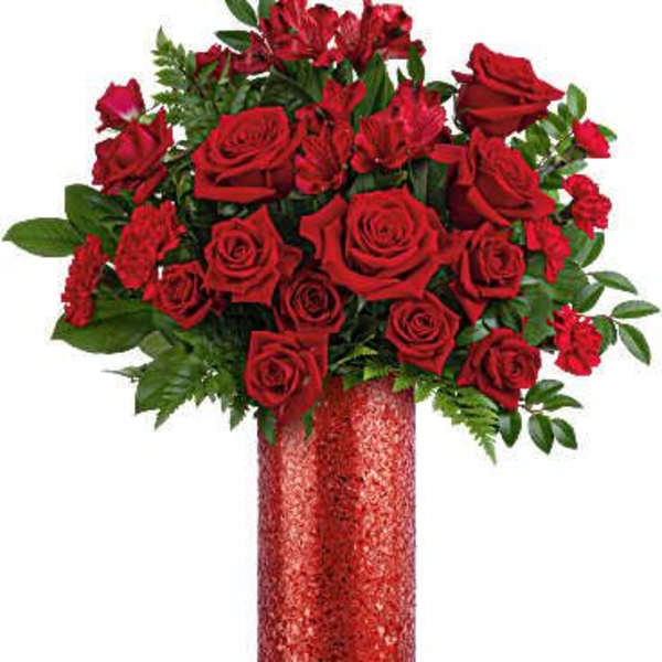Red roses arranged in a tall glittery vase