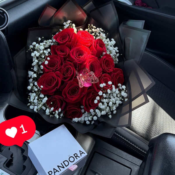 Bouquet of red roses with white baby's breath in black wrap