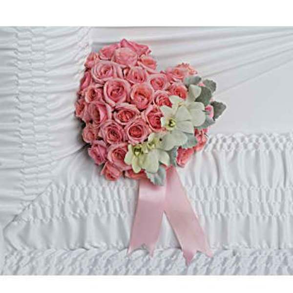 Pink rose bouquet with pale green accents and a pink ribbon on white fabric
