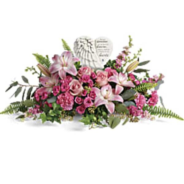 Low pink lily and rose sympathy arrangement with a white heart memorial stone in the center