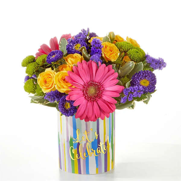 Colorful bouquet in a striped vase with a pink gerbera daisy and yellow roses