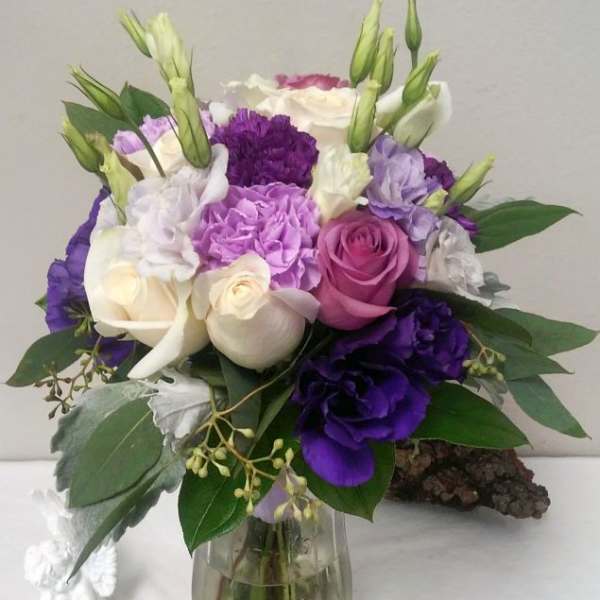 Bouquet of purple, pink, and white flowers in a glass vase