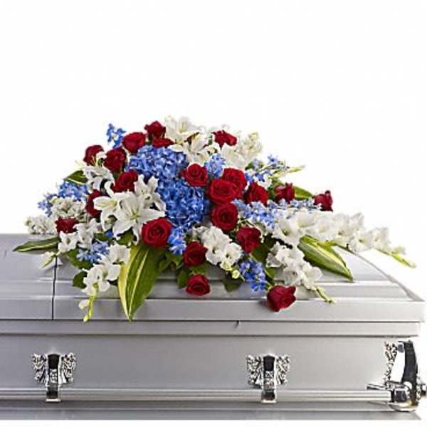 Red, white, and blue floral spray on a silver casket