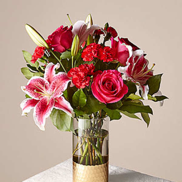 Mixed bouquet of pink roses and lilies in a glass vase