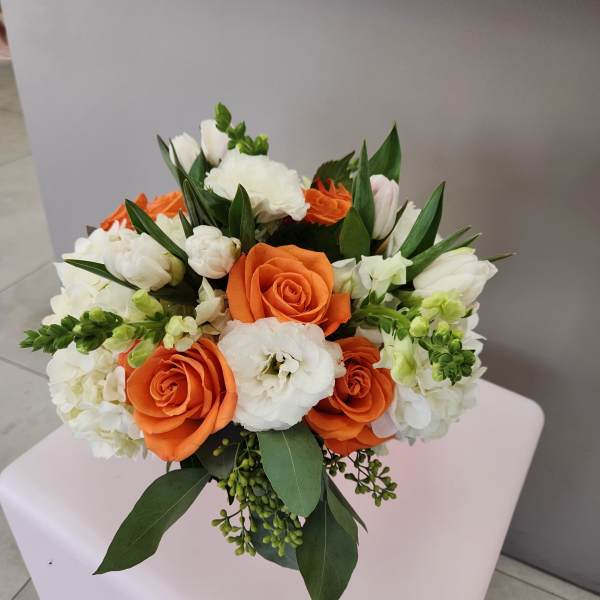 Round arrangement of orange roses and white blooms with green accents in a compact mixed bouquet