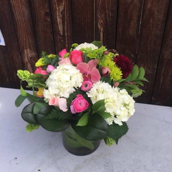 Pink and white mixed flower arrangement in a glass vase