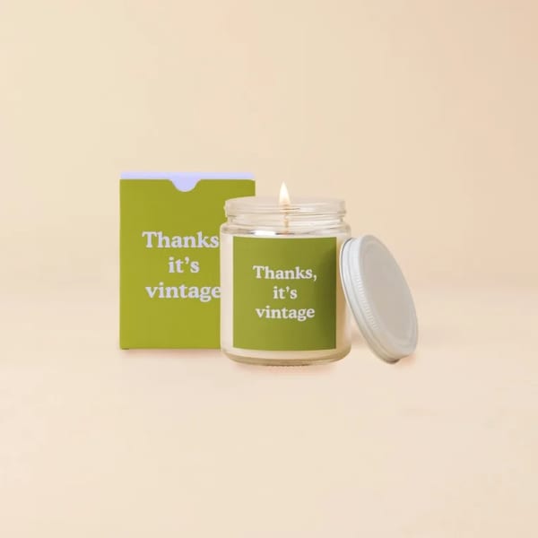 Lit candle in a glass jar with a matching box