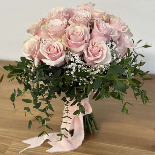 Bouquet of pale pink roses with white filler flowers and greenery