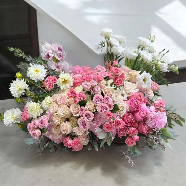 Large pink and white floral arrangement in a low container