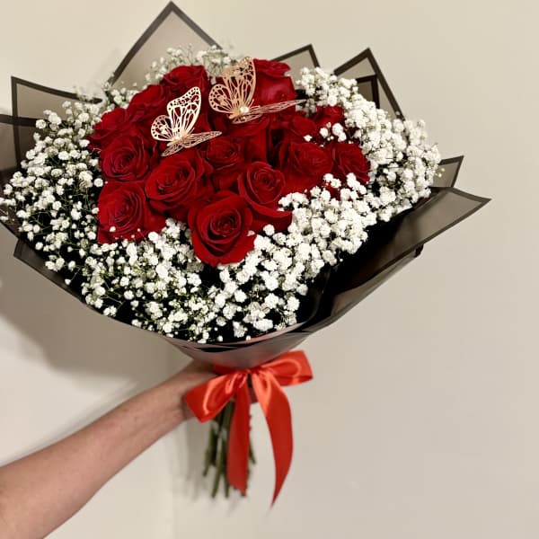 Bouquet of red roses with white baby's breath and a red ribbon