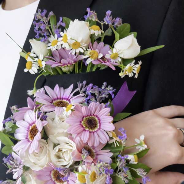 Pink daisies and white roses arranged as a boutonniere and bouquet set