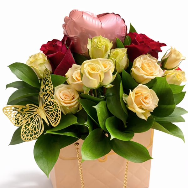 Bouquet of red and cream roses in a gift box with a pink heart balloon