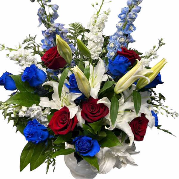 Red, white, and blue bouquet with roses and lilies in a vase