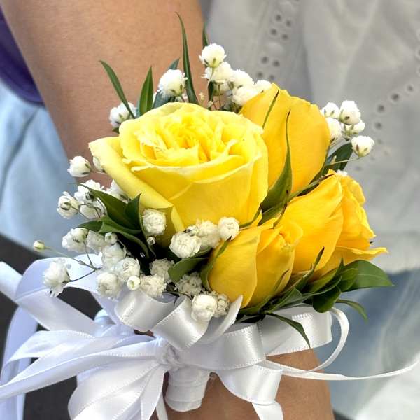 Yellow rose wrist corsage with white baby's breath and ribbon ties