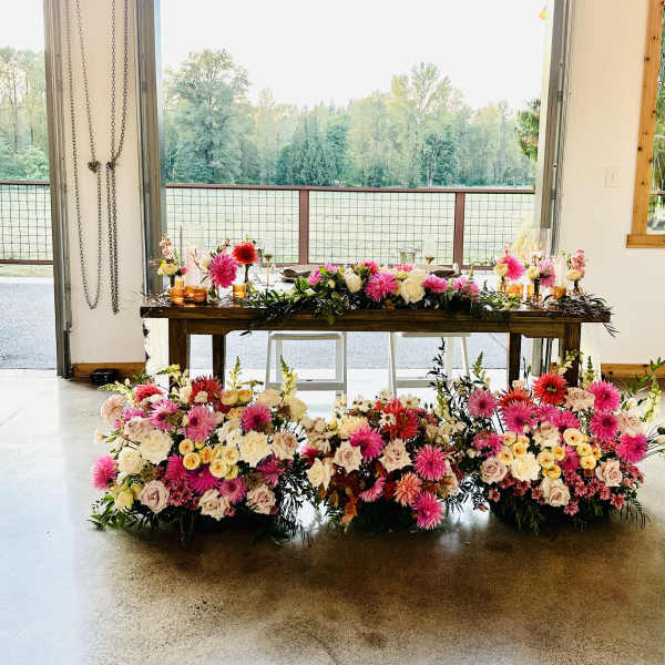 Large floral table arrangement with pink, white, and red blooms