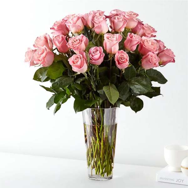 Pink roses arranged in a clear glass vase