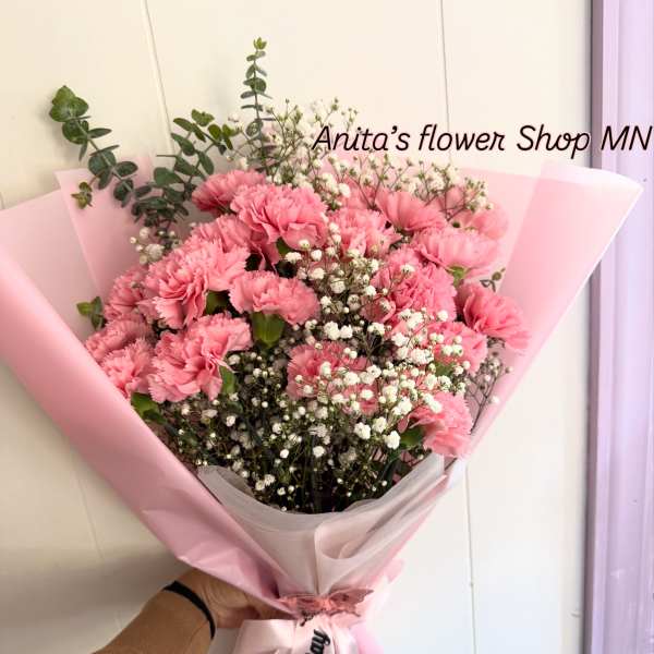 Pink carnation bouquet wrapped in pastel paper with a birthday ribbon