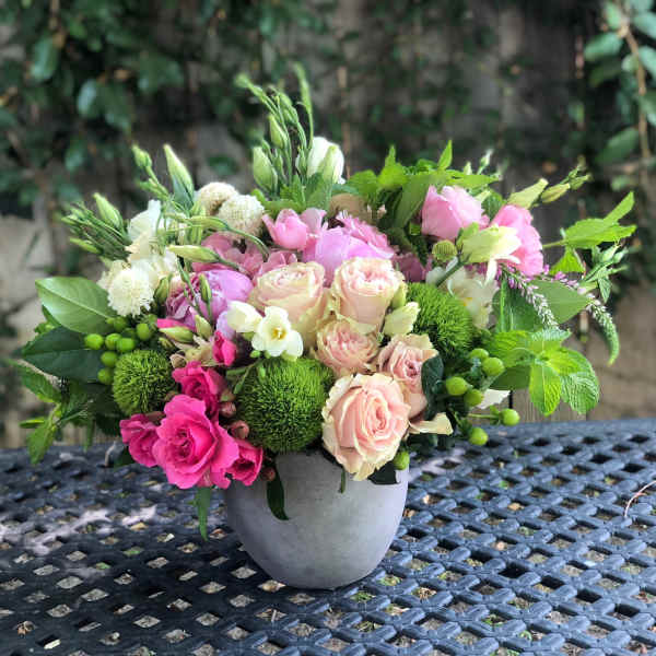 Pink and cream roses in a gray vase with green accents