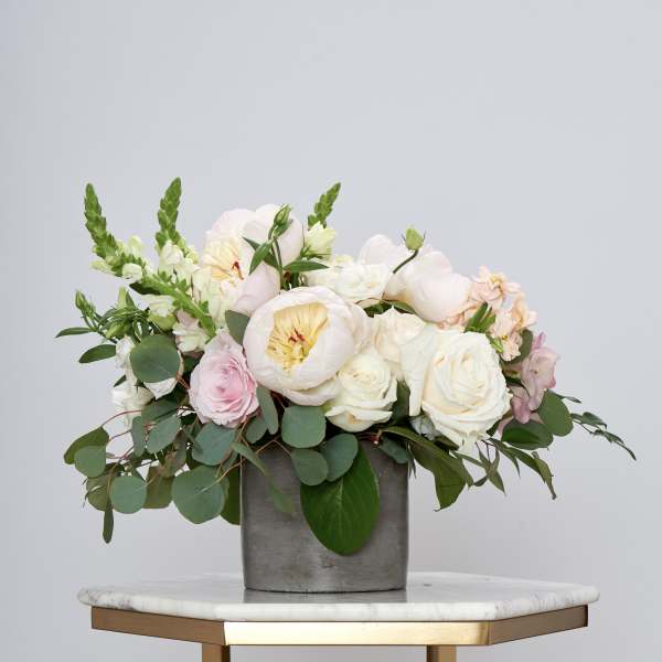 Blush and white floral arrangement in a gray vase