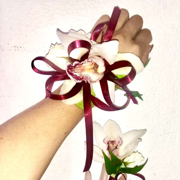 White orchid corsage and boutonniere with burgundy ribbon