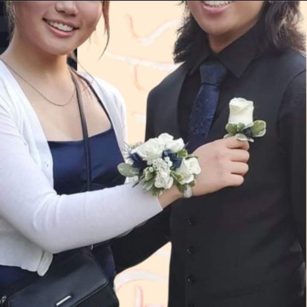 Couple wearing white rose corsage and boutonniere
