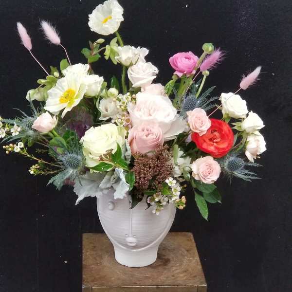 Mixed bouquet in a white vase with pink, white, and red blooms