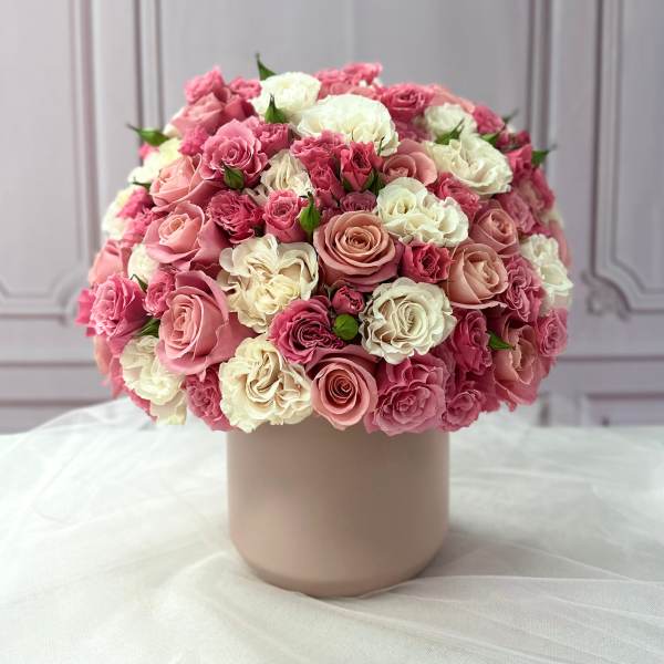 Pink and white rose bouquet in a blush cylindrical vase