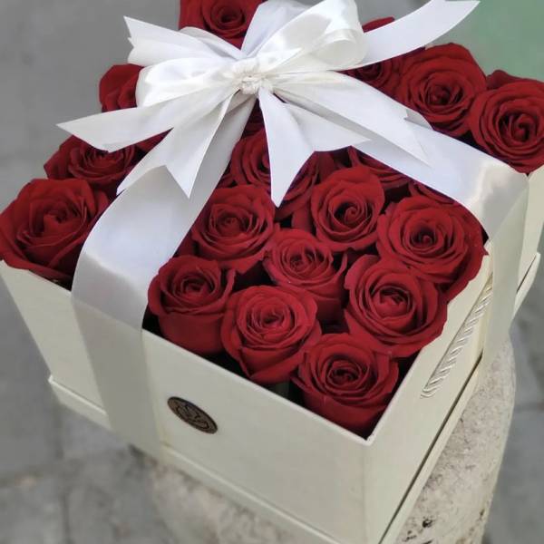 Box of red roses tied with a white ribbon