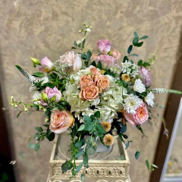 Blush roses and white hydrangeas arranged in a decorative vase