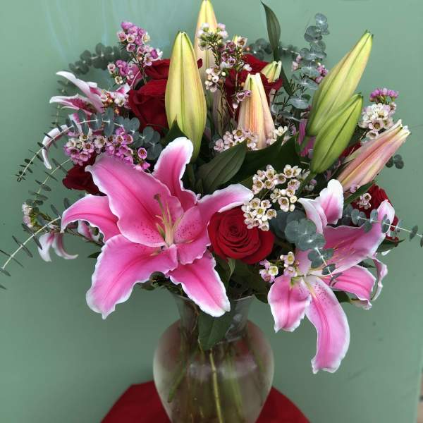 Pink lilies and red roses in a glass vase