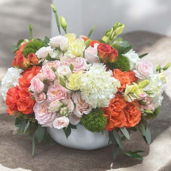 Mixed bouquet of roses and white hydrangeas in a white bowl vase