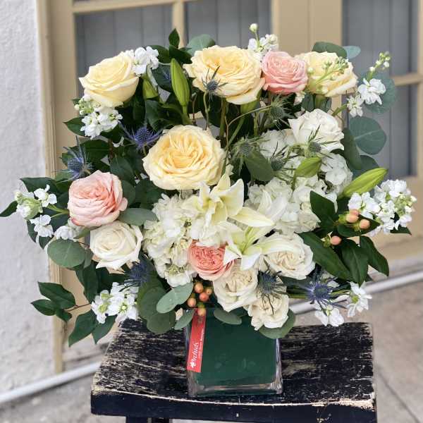 Bouquet of cream, pink, and white roses in a glass vase