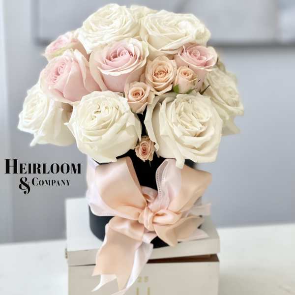 Bouquet of pale pink and white roses tied with a blush ribbon