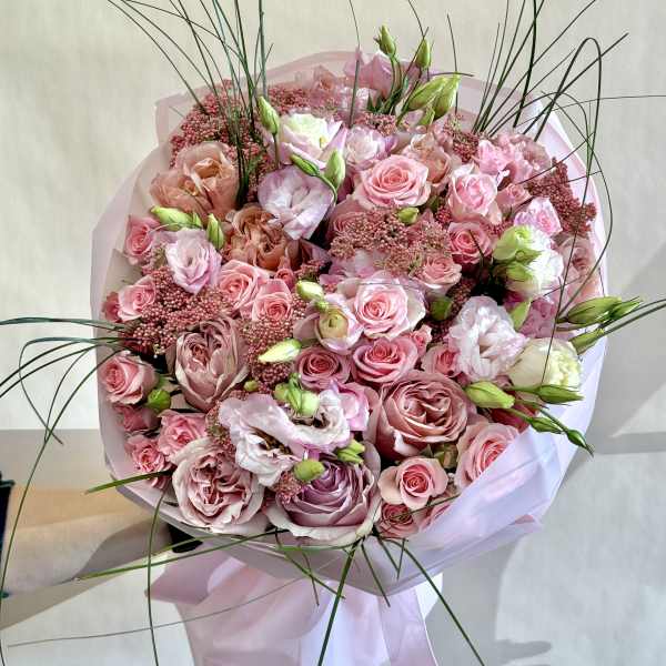 Large pink bouquet of roses and lisianthus with tall grass accents