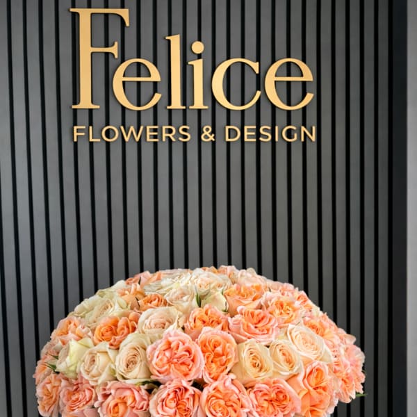 Large peach and cream rose arrangement in a round gray container