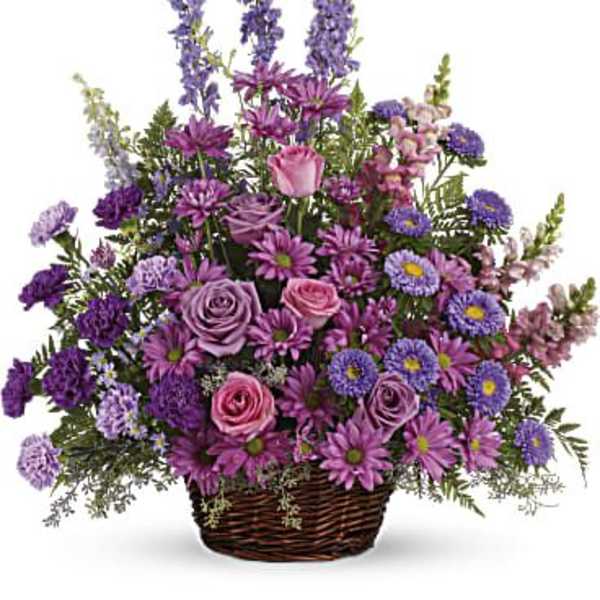 Purple and pink mixed flower arrangement in a wicker basket