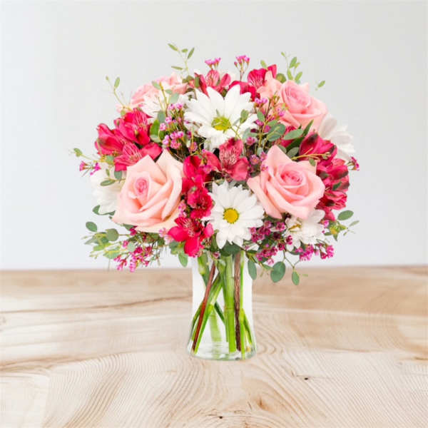Pink roses and white daisies in a clear glass vase