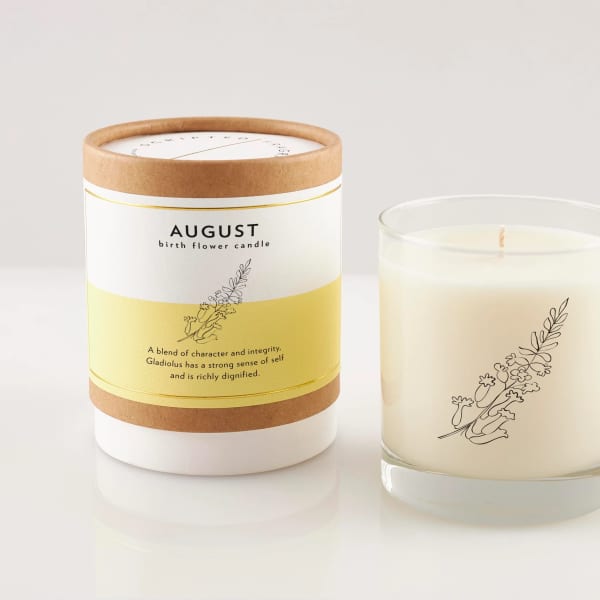 Two birth flower candles, one in a labeled box and one in a glass jar