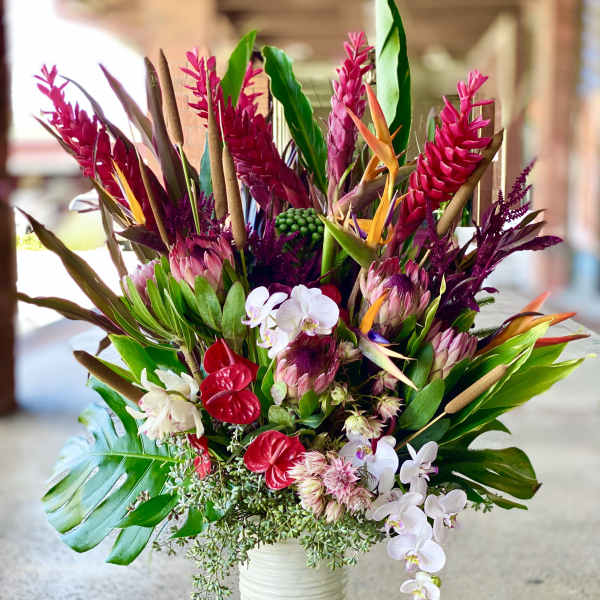 Tropical bouquet in a white vase with pink and white orchids