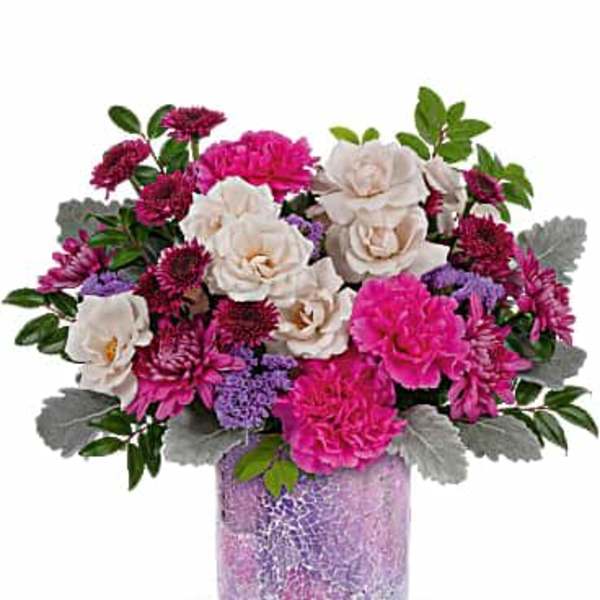 Pink and white mixed flower arrangement in a purple vase