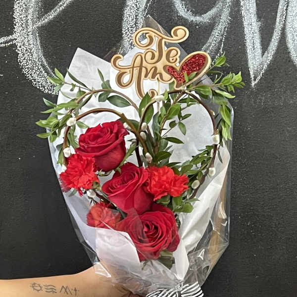 Bouquet of red roses and carnations with a decorative topper