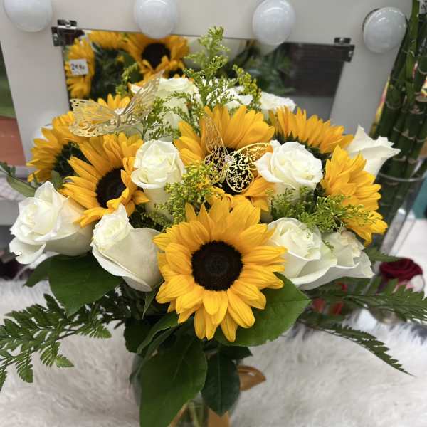 Bouquet of sunflowers and white roses in a glass vase