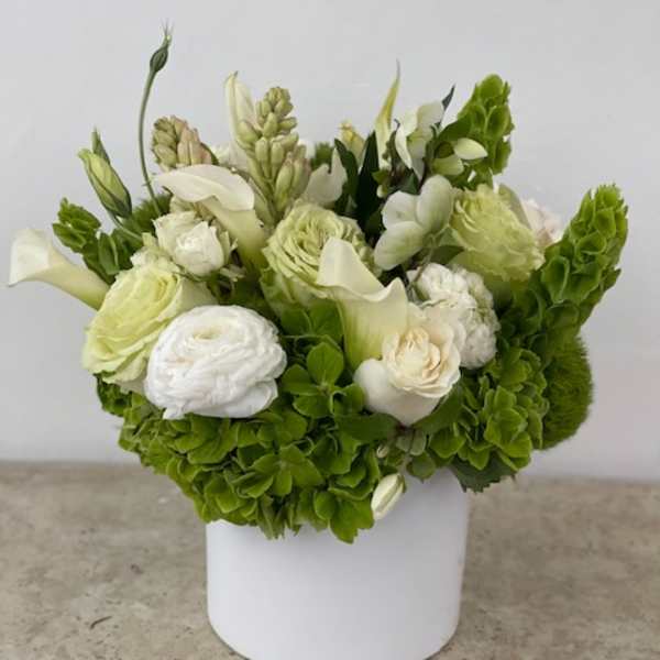 White and green floral arrangement in a white box