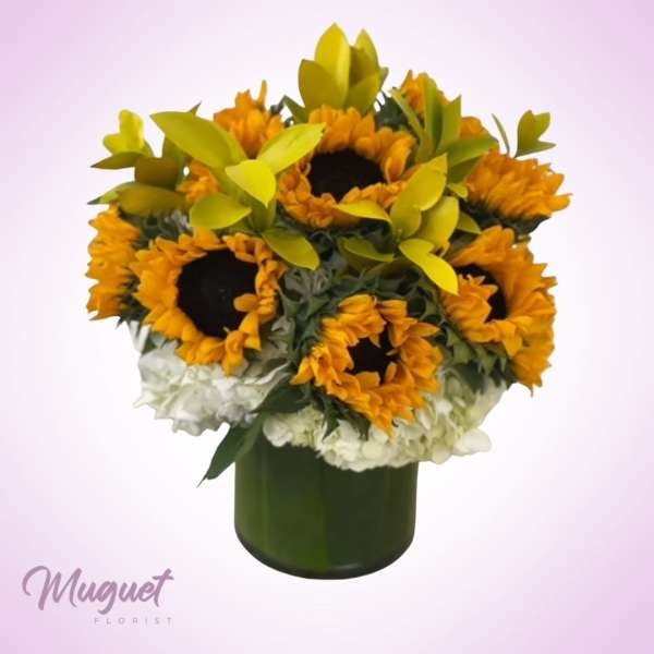 Sunflower bouquet in a dark green vase with white flowers below