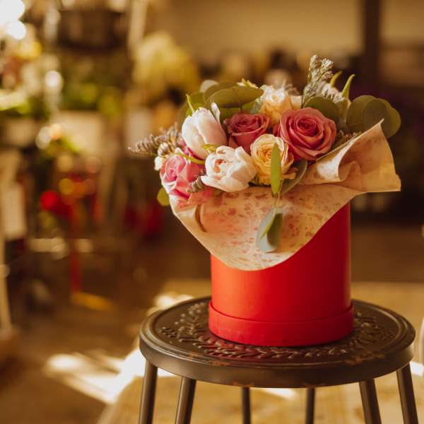 Bouquet of pink and white roses in a red hat box