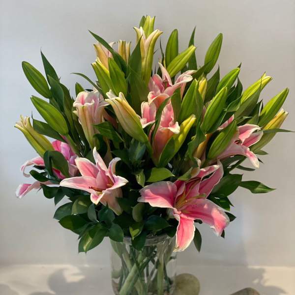 Pink lilies arranged in a clear glass vase