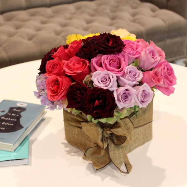 Bouquet of multicolored roses in a burlap-wrapped box