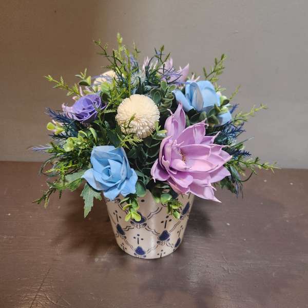Mixed artificial flowers in a patterned ceramic pot